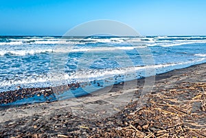 Beach with rough sea in a sunny day