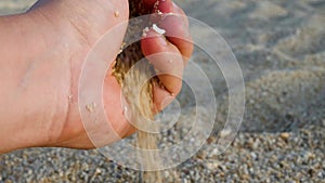 Beach sand flowing from male's hand