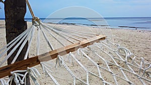 Beach, sand, hammock between two palm trees