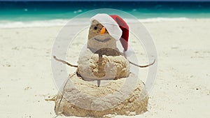 A beach sand man sculpture wishes a Merry Christmas