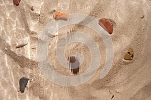 Beach sand with marine stones under the water texture