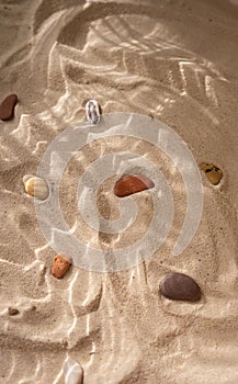 Beach sand with marine stones under the water texture shadows