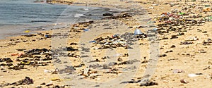 Beach sand and ocean with so many garbage plastic pollution in Senegal