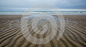 Beach Sand Patterns With Ocean Waves Under A Grey Sky