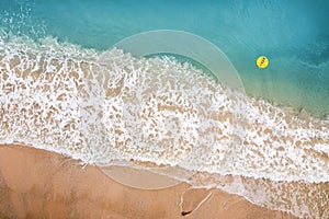 Beach sand sea with Blue wave and white foamy summer background. Aerial beach top view