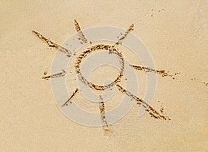 Beach sand surface with simple sun drawing