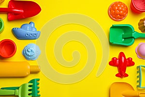 Beach sand toys on yellow background, flat lay. Space for text