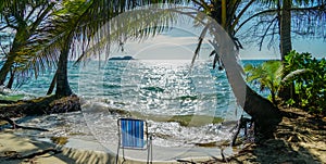 Beach scene with beach chair under coconut palms, Chang island, Thailand