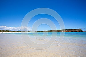 Beach scene with clear blue water, blue sky and sandy shore seen from Puerto Rico