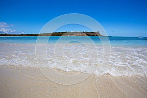 Beach scene with clear blue water, blue sky and sandy shore seen from Puerto Rico