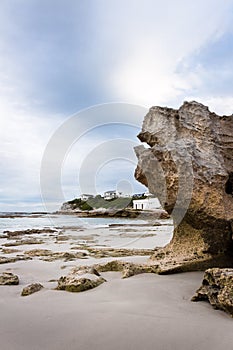 Beach scene with clouds and rocks in foreground