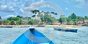 Beach scene featuring palm trees and boats near the shore. Sao Tome and Principe.