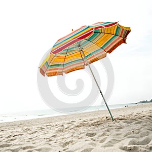 Beach Scene with Umbrella Isolated on White Background photo