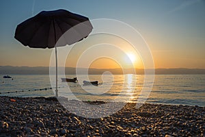 Beach scenery with sunshade and boats in the early morning, Moscenicka Draga croatia