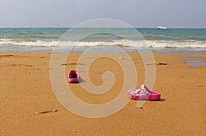 Beach sea and children`s slippers