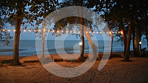 Beach with sea and lamp decoration on the tree in resort