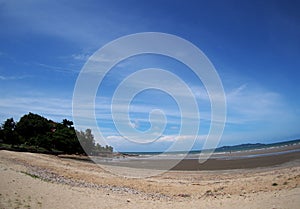 Beach sea scene view with deep blue sky and brown beach sand and stones