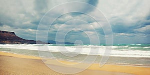 Beach and sea with strong waves, stormy sky, dark clouds background