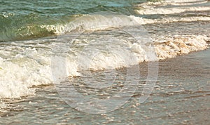 beach and sea in summer. Close up of waves of the sea. Texture of bubbles. Summer background.