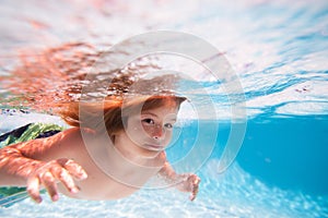 Beach sea and water fun. Child swim under water in sea. Kid swimming in pool underwater. Happy boy swims in sea