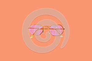 Beach set on peach background. Women`s accessories items. Summer vacation concept. Pink sunglasses pattern on peach background.