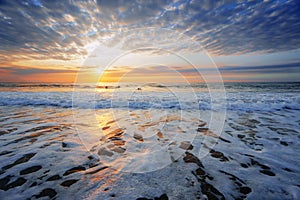 Beach shore at sunset with some surfers