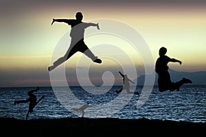 Beach silhouettes jump for joy