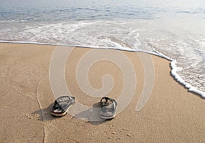 Beach slippers in the sand on beach