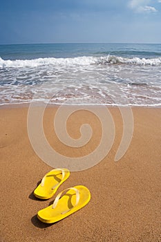 Beach slippers on sandy beach