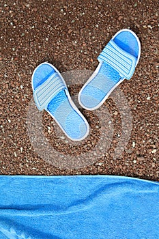 Beach slippers and a towel to lie on a pebble beach.