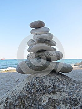 Beach stone zen cairn. A stone pyramid on sea shore. Simple poise pebbles stack, rock zen sculpture, a stone tower