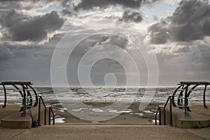 Beach on a stormy day with sun rays breaking through the clouds