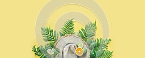 Beach straw hat, fern leaves and citrics on yellow background. Space for text. Summer concept. Banner