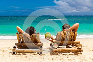 Beach summer couple on island vacation holiday relax in the sun
