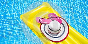 Beach summer holiday background. Inflatable air mattress, flip flops and hat on swimming pool. Yellow lilo and summertime