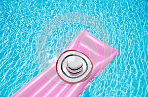 Beach summer holiday background. Inflatable air mattress and hat on swimming pool. Pink lilo and summertime accessories