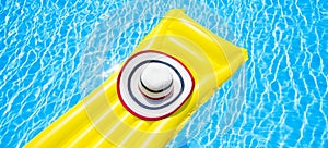 Beach summer holiday background. Inflatable air mattress and hat on swimming pool. Yellow lilo and summertime accessories