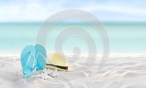 Beach summer holiday banner background. Flip flops and hat on sand near ocean. Summertime accessories on seaside. Tropical