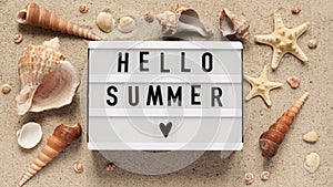 Beach summer vacation banner concept.Text board with the inscription HELLO SUMMER , seashells and starfish lie on the sand, top