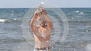 Beach summer vacation. Children`s emotions. The child develops tinsel in the wind.