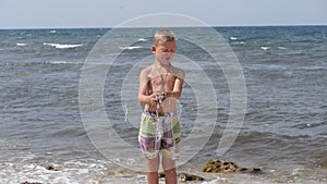 Beach summer vacation. Children`s emotions. The child develops tinsel in the wind.