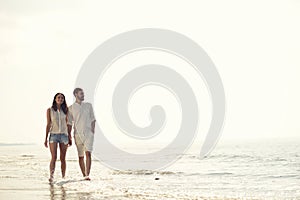 Happy fun beach vacations couple walking together laughing having fun on travel destination.