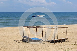 Beach sun beds blue ocean fishing boat, Hoi, Vietnam