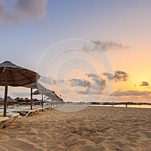 Beach sunbeds and umbrellas, sunset