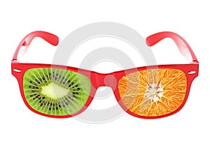 Beach sunglasses concept with kiwi and orange fruit on white background