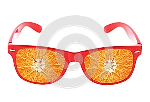 Beach sunglasses concept with orange fruit on white background