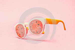 Beach sunglasses concept with watermelon on pink background