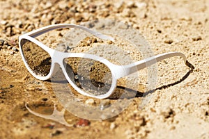 Beach sunglasses in the sea wave