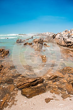 Beach on a sunny day. The Indian Ocean at Cape Agulhas, the southernmost tip of Africa.
