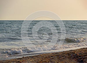 Beach on a Sunny summer day during sunset. Landscape with sea sunset on beach. The sea wave came ashore in a sunset color. In the